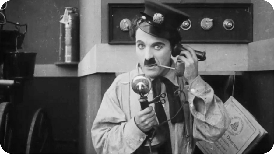 Charlie Chaplin au téléphone en tenue de pompier. Photo extraite du court métrage 