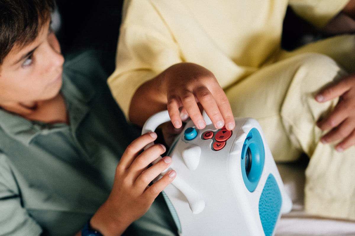 Un enfant choisit son histoire avec les gros boutons du projecteur Tikino